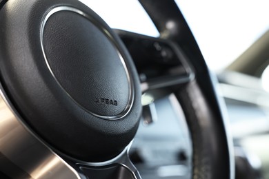 Photo of Steering wheel inside of black modern car, closeup