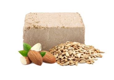 Image of Tasty halva, peeled sunflower seeds, almonds and green leaves isolated on white