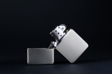 Photo of Gray metallic cigarette lighter on black background, closeup
