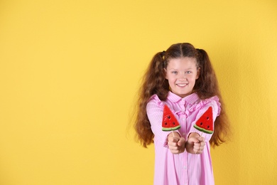Photo of Little girl with candies on color background. Space for text