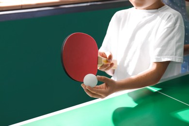 Photo of Little boy playing ping pong indoors, closeup