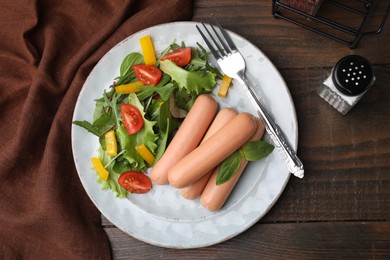 Photo of Delicious boiled sausages with salad on wooden table, top view