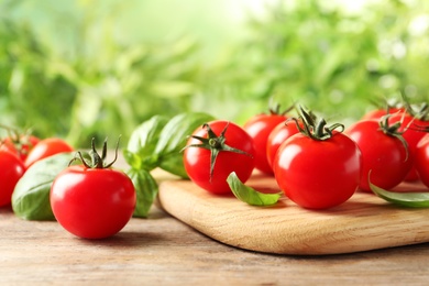 Photo of Board with fresh cherry tomatoes on wooden table
