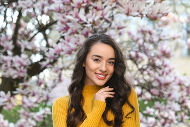 Photo of Beautiful woman near blossoming magnolia tree on spring day