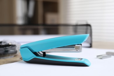 Photo of Stapler and paper on table indoors, closeup