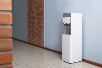 Photo of Modern water cooler in office hall
