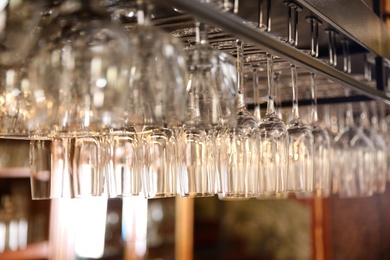 Photo of Many clean glasses on metal rack in restaurant