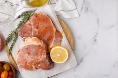 Photo of Flat lay composition with raw marinated meat, lemon and rosemary on white marble table. Space for text