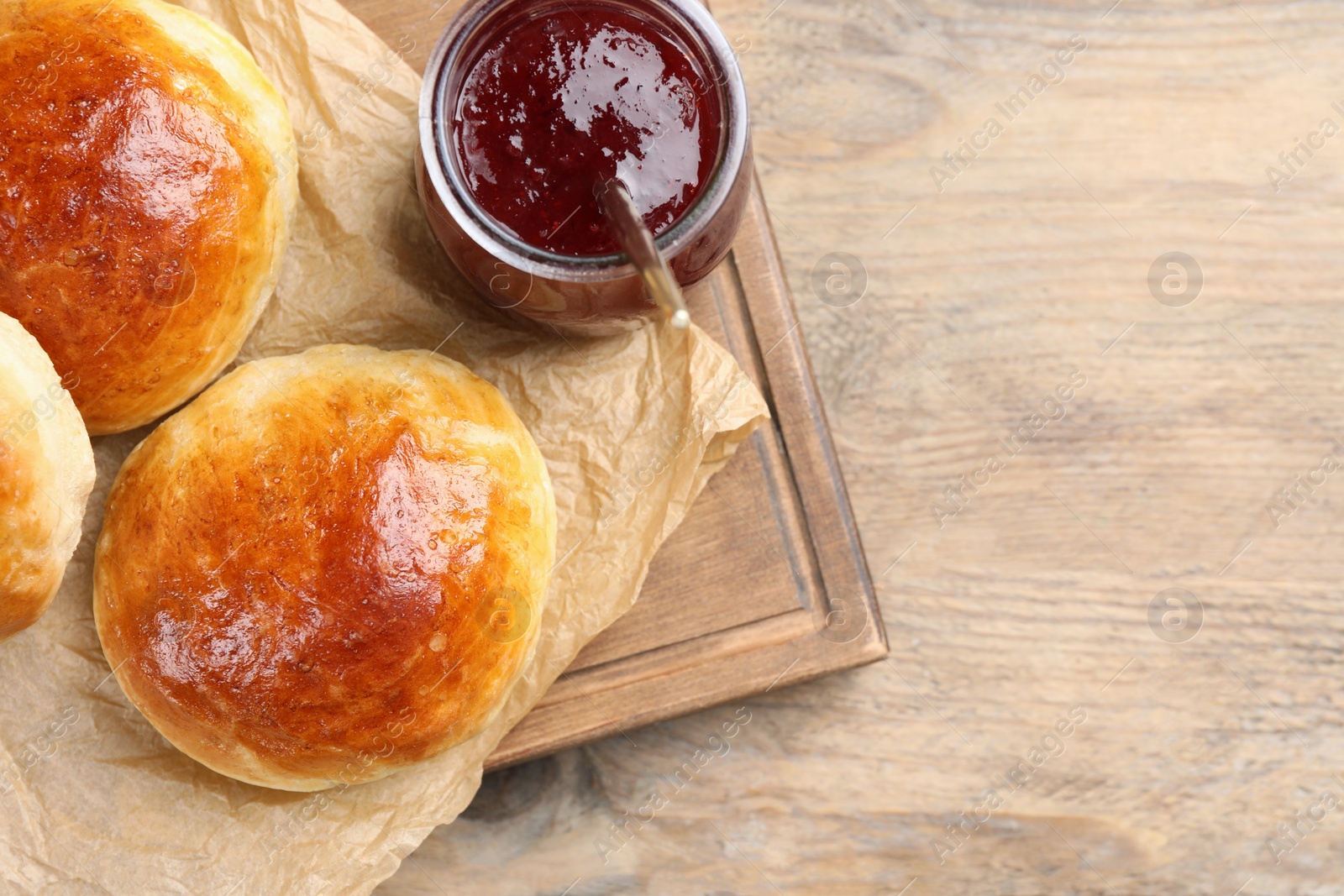 Photo of Tasty scones prepared on soda water and jam on wooden table, top view. Space for text
