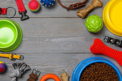 Photo of Frame of different dog collars, accessories and food on grey wooden background, flat lay. Space for text