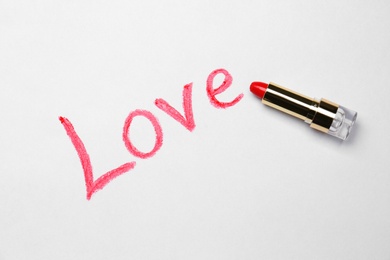 Photo of Word LOVE written with lipstick on white background, top view