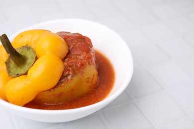 Photo of Delicious stuffed bell peppers on white tiled table. Space for text