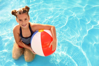Photo of Happy girl with inflatable ball in swimming pool