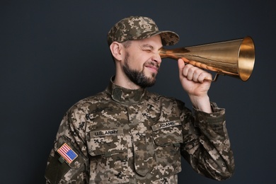 Photo of Military man with megaphone on gray background