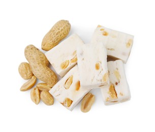 Photo of Pieces of delicious nougat and nuts on white background, top view