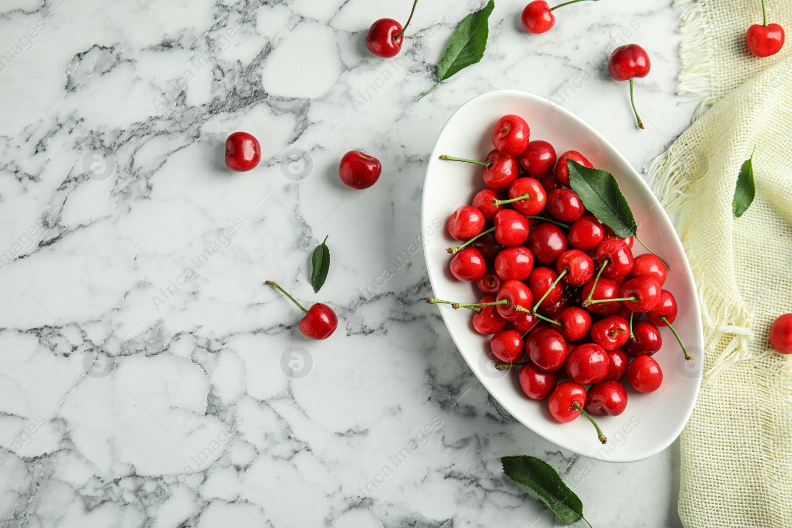 Photo of Bowl with sweet red cherries on marble table, top view