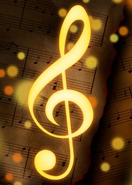 Image of Golden treble clef and burnt sheets with music notes on background, bokeh effect. Beautiful illustration design