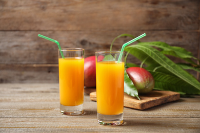 Photo of Fresh delicious mango drink on wooden table