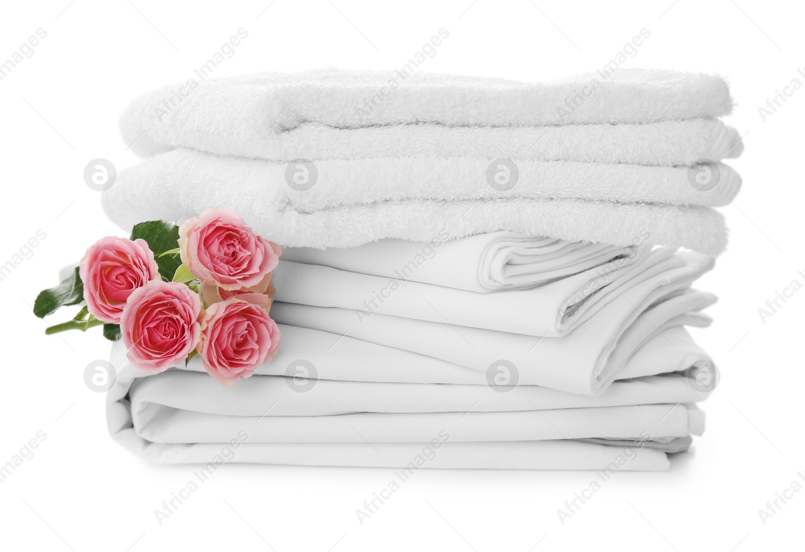 Photo of Stack of towels and bed sheets with roses on white background