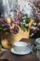 Photo of Beautiful spring flowers on table served for tea drinking in garden, closeup