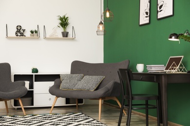 Photo of Modern living room interior with workplace near green wall