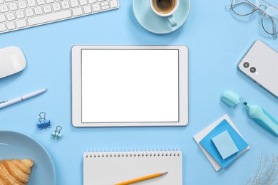 Photo of Flat lay composition with modern tablet on light blue background. Space for text