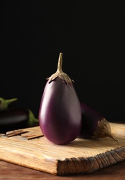 Photo of Ripe purple eggplants on wooden table, closeup