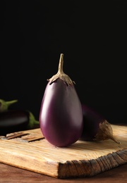 Photo of Ripe purple eggplants on wooden table, closeup