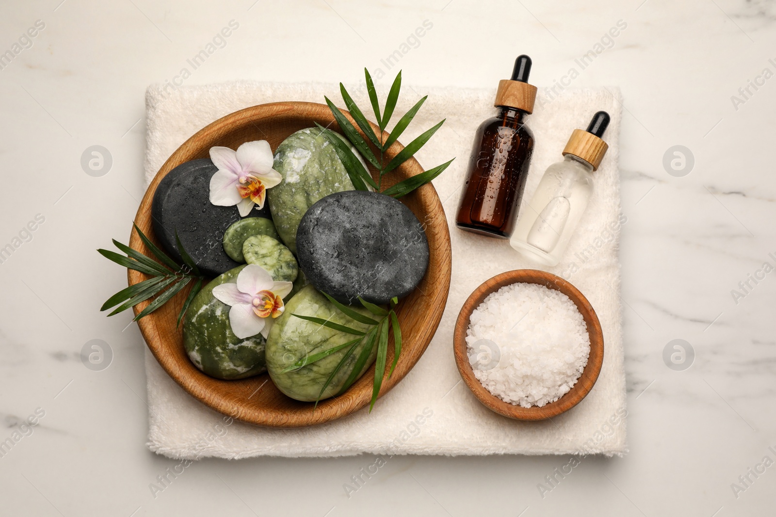 Photo of Flat lay composition with different spa products and flowers on white marble table