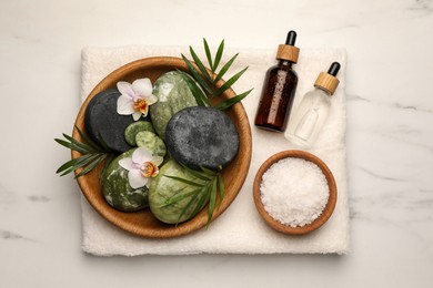 Photo of Flat lay composition with different spa products and flowers on white marble table