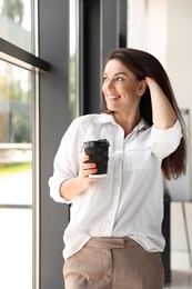 Photo of Portrait of female business trainer with cup of coffee indoors