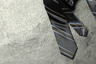 Photo of One striped necktie on grey textured background, top view. Space for text