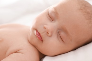 Photo of Cute little baby sleeping on bed, closeup