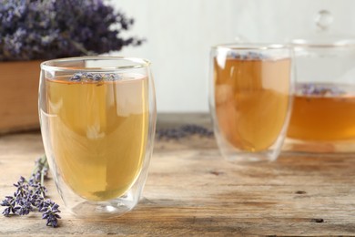 Photo of Fresh delicious tea with lavender in glass on wooden table