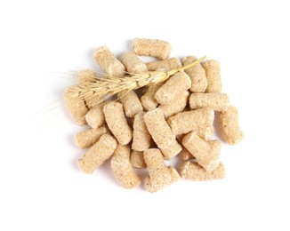 Photo of Pile of granulated wheat bran and spikelet on white background, top view