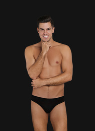Photo of Handsome man in underwear on black background