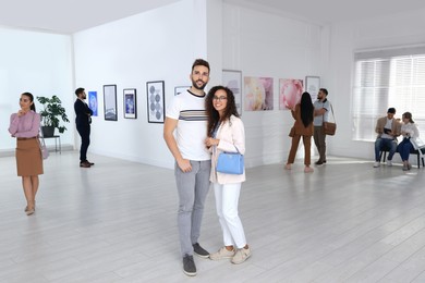 Happy couple at exhibition in art gallery