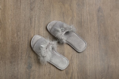 Photo of Pair of soft slippers on wooden background, flat lay