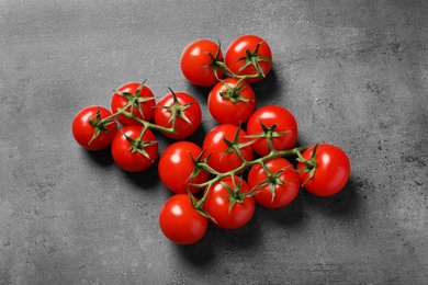 Photo of Fresh cherry tomatoes on stone background, flat lay