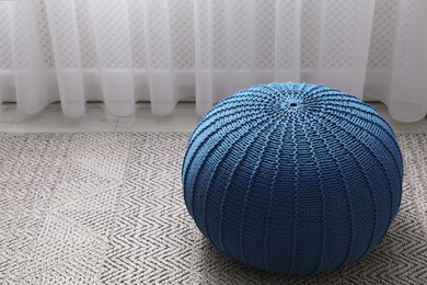 Stylish blue pouf on floor in room, space for text