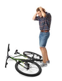 Emotional young man with bicycle on white background