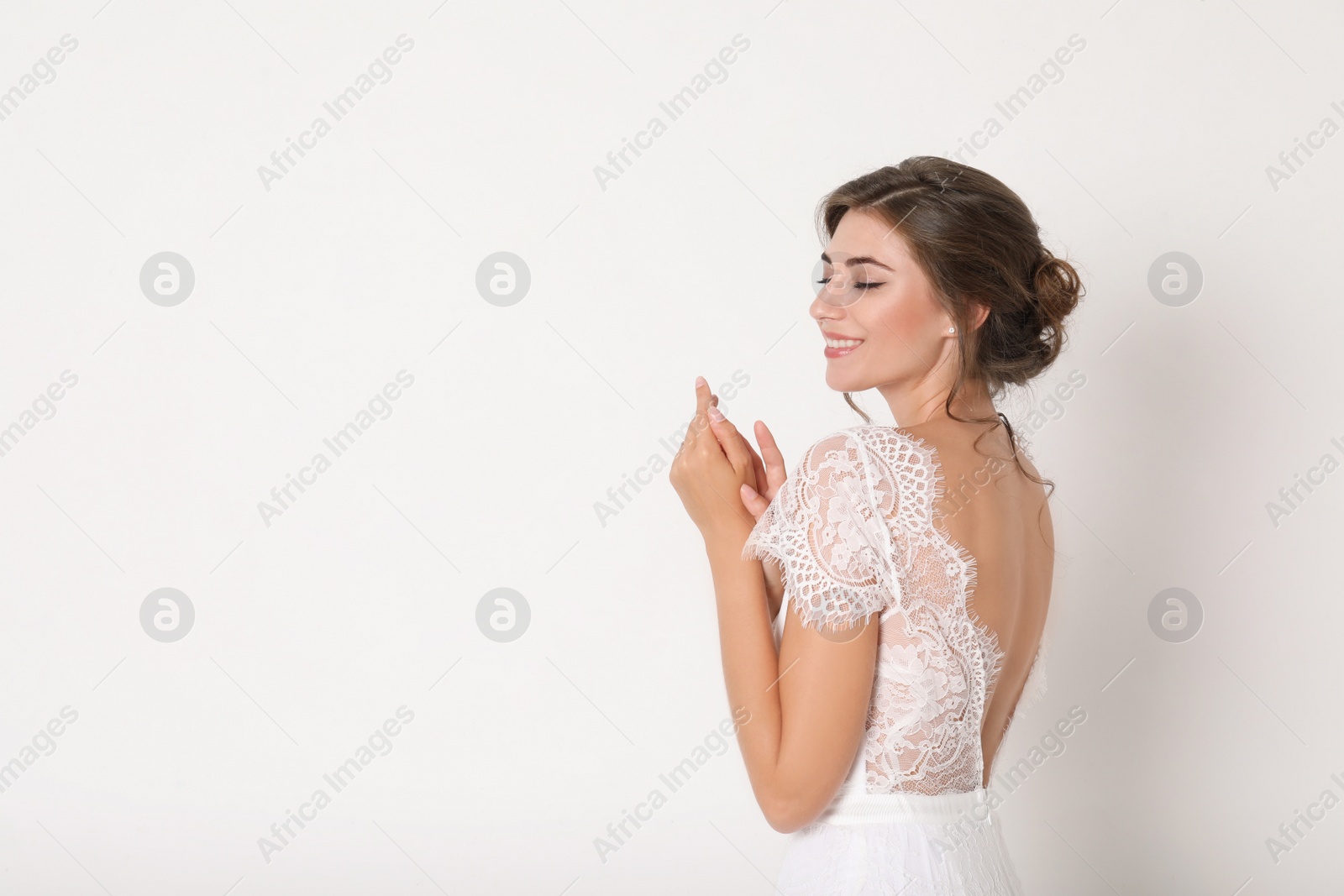 Photo of Young bride wearing beautiful wedding dress on light background. Space for text