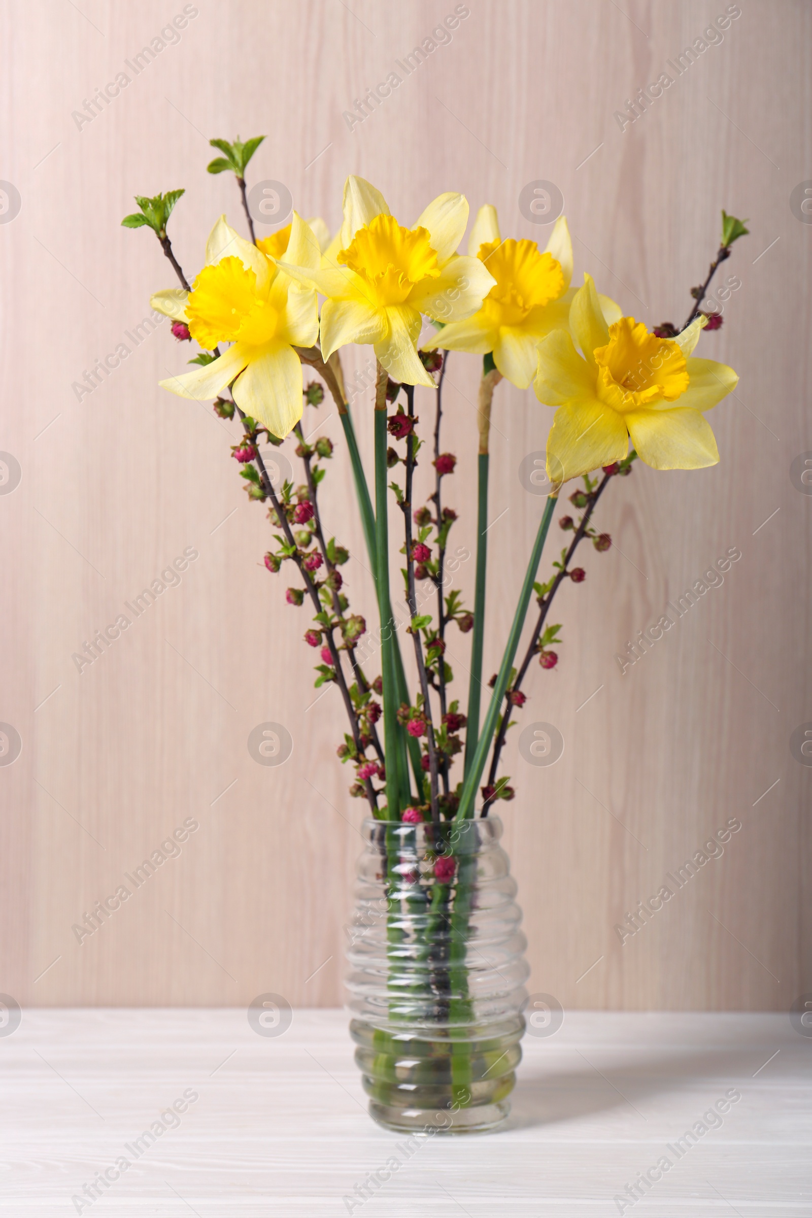Photo of Bouquet of yellow daffodils and beautiful flowers in vase on white table