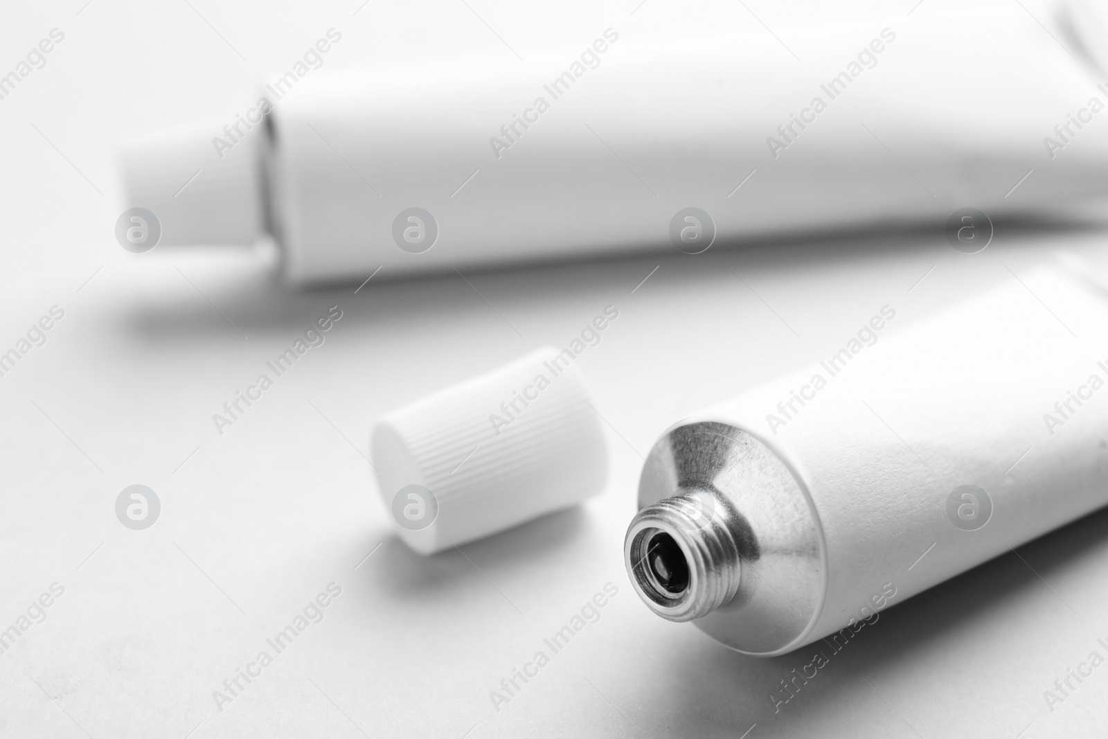 Photo of Open ointment tube on white background, closeup