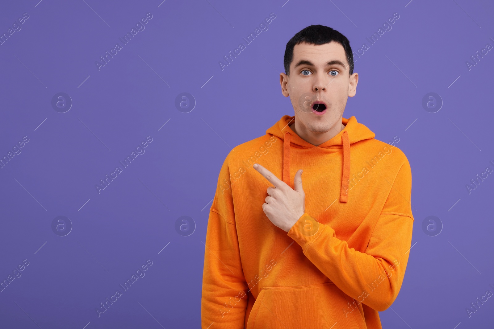 Photo of Portrait of surprised man on purple background, space for text