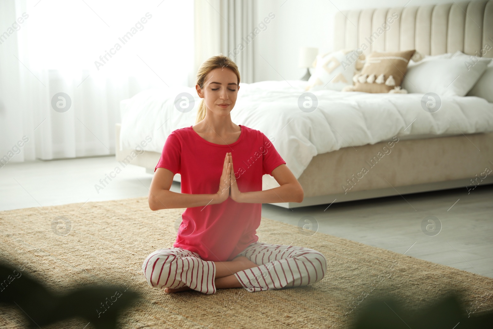 Photo of Young woman meditating on floor at home. Morning fitness