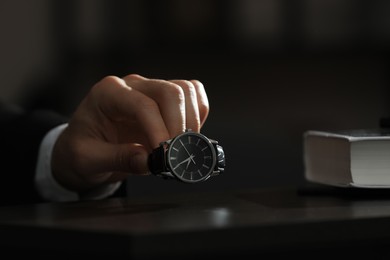 Photo of Man putting luxury wrist watch on table, closeup. Space for text