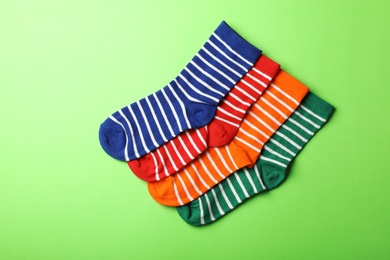 Cute child socks on color background, top view
