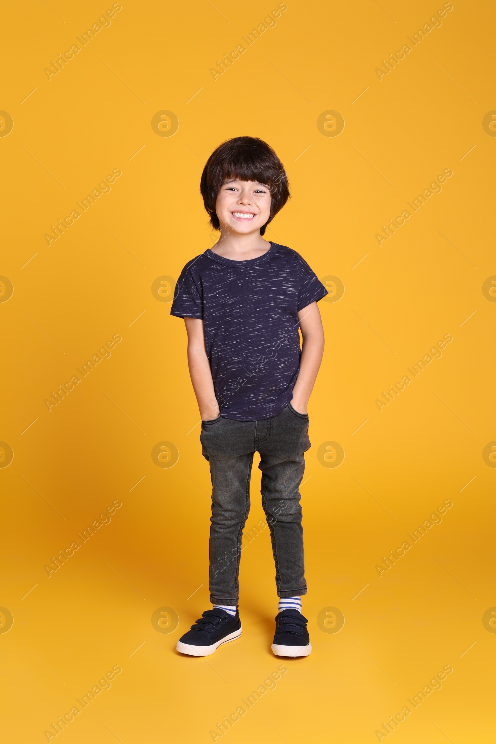 Photo of Full length portrait of cute little boy on yellow background