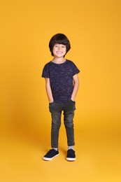 Photo of Full length portrait of cute little boy on yellow background